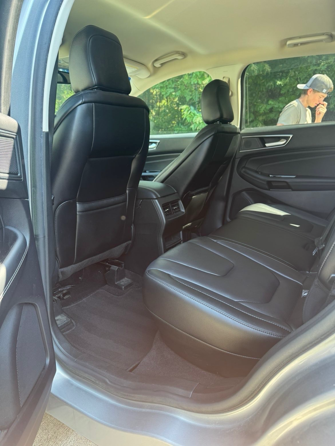 Freshly detailed SUV interior with clean black leather seats and vacuumed carpet